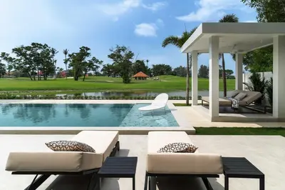 a swimming pool with two chairs and a pavilion at \u62c9\u53e4\u5a1c\u9ad8\u5c14\u592b\u4ff1\u4e50\u90e8\u522b\u5885 in Ban Nong Chaeng