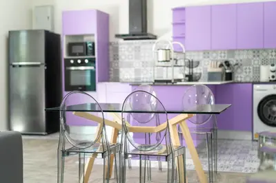 a purple kitchen with a glass table and chairs at Brand New Design 2BR Villa Indra with Oxygen Pool in Rawai Beach