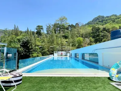 a swimming pool with a view of a house at Fantasea Condo - Kamala in Kamala Beach