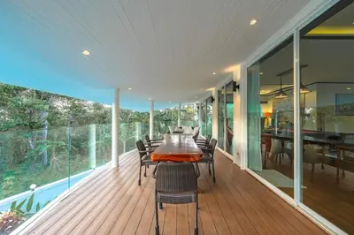 a dining room with a table and chairs on a deck at V175 Huge 21M Pool 5-BR 1Km 2 Kamala Beach in Kamala Beach