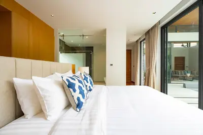 a bedroom with a large white bed with white pillows at 3BR Pool Villa at Botanica Modern Loft in Bangtao in Bang Tao Beach