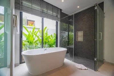 a bathroom with a tub and a glass shower at 3BR Pool Villa at Botanica Modern Loft in Bangtao in Bang Tao Beach