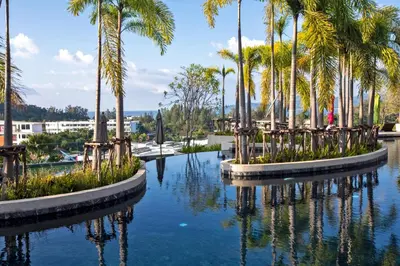 a pool of water with palm trees in it at 1bdr Seaview Apartment near Surin Beach in Surin Beach