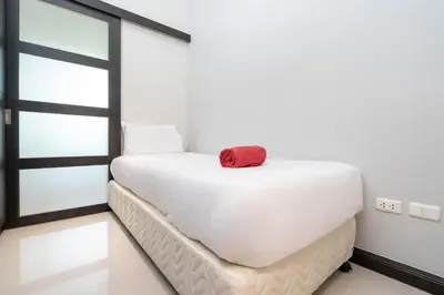 a white bed with a red towel on top of it at Balinese Style 3BR Villa Morning Forest, Nai Harn in Rawai Beach
