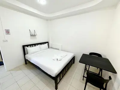a small bedroom with a bed and a desk at Patong Canal Villa 107 in Patong Beach