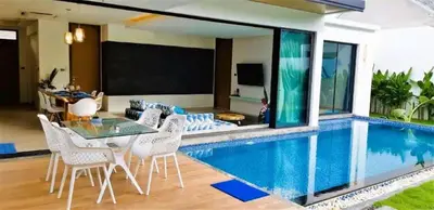a living room with a pool with a table and chairs at 01 - Beach Villa Retreat in Nai Yang Beach