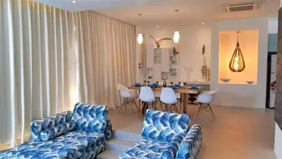 a living room with blue couches and a dining room at 01 - Beach Villa Retreat in Nai Yang Beach