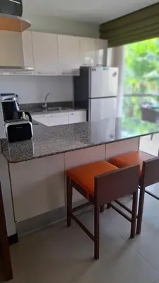 a kitchen with a counter with two chairs and a table at One bed Apartment Nai Yang in Nai Yang Beach