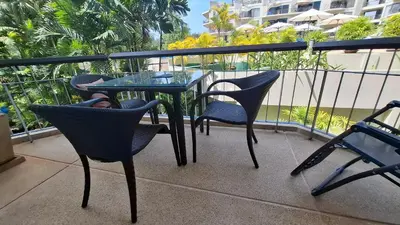a glass table and chairs on a balcony at One bed Apartment Nai Yang in Nai Yang Beach