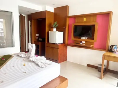 a living room with a bed and a tv at Arisa Hotel Patong Beach in Patong Beach