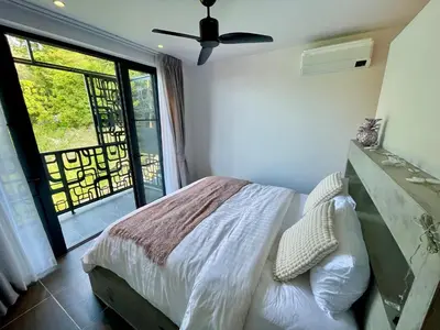 a bedroom with a bed and a ceiling fan at Kata Luxury Apartment Matriochka 2BR En-suite in Kata Beach