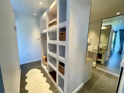 a bathroom with a walk in closet with a mirror at Kata Luxury Apartment Matriochka 2BR En-suite in Kata Beach