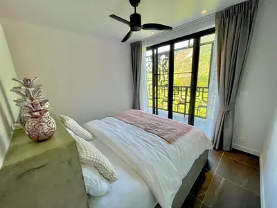 a bedroom with a bed and a ceiling fan at Kata Luxury Apartment Matriochka 2BR En-suite in Kata Beach