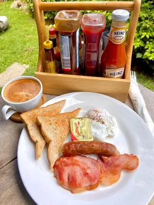 a plate of breakfast food with bacon toast and eggs at Kata Luxury Apartment Matriochka 2BR En-suite in Kata Beach
