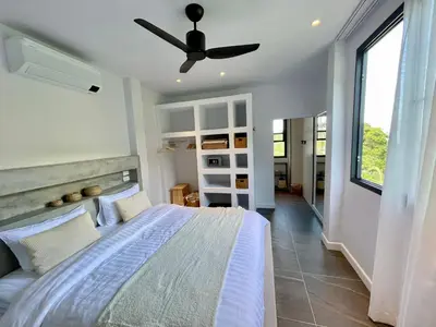 a bedroom with a bed and a ceiling fan at Kata Luxury Apartment Matriochka 2BR En-suite in Kata Beach