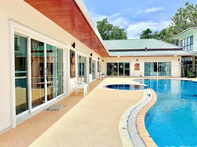 a house with a swimming pool next to a house at Chuan Pool Villa Rawai Phuket in Rawai Beach