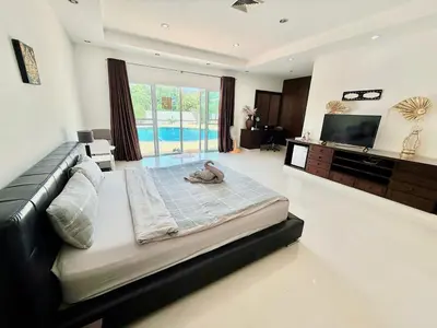 a large bedroom with a large bed and a television at Chuan Pool Villa Rawai Phuket in Rawai Beach