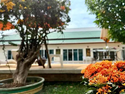 a tree in a pot next to some flowers at Chuan SeaFront Villa Rawai Phuket in Rawai Beach