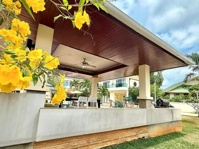 a covered porch of a house with yellow flowers at Chuan SeaFront Villa Rawai Phuket in Rawai Beach
