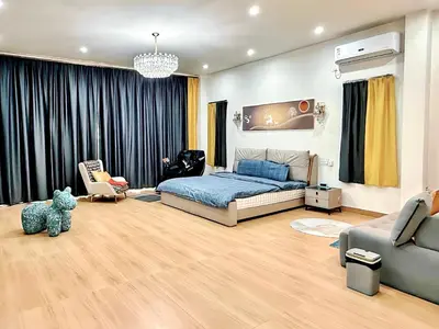 a bedroom with a bed and a living room at Chuan SeaFront Villa Rawai Phuket in Rawai Beach
