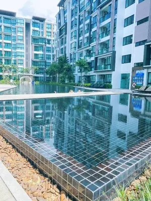 a swimming pool in front of some apartment buildings at Royal Lee Phuket Condominium AirportB in Ban Bo Han