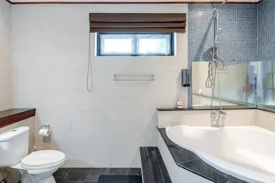 a bathroom with a tub and a toilet and a sink at Lantern Villa Private Pool Villa in Ban Klang