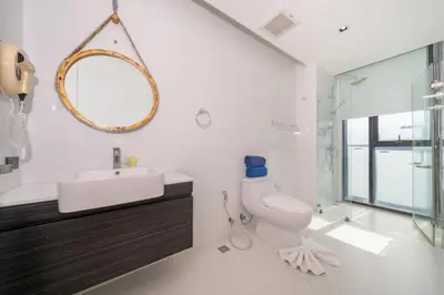 a bathroom with a toilet and a sink and a mirror at Sea & Mountain Views Apartment A602 at VV Patong in Patong Beach