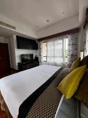 a large bedroom with a large white bed with yellow pillows at Villa Laguna Bang Tao in Laguna Phuket