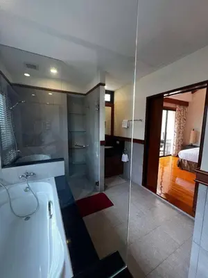 a bathroom with a bath tub and a bedroom at Villa Laguna Bang Tao in Laguna Phuket