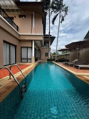 a swimming pool in front of a house at Villa Laguna Bang Tao in Laguna Phuket