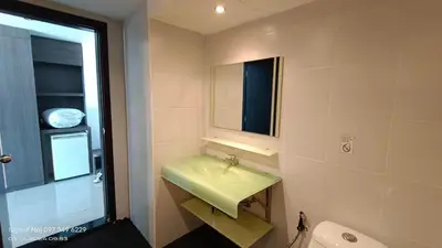 a bathroom with a green sink and a mirror at Bay Shore Ocean View by Get A Rent Phuket in Patong Beach