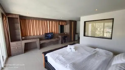 a bedroom with a bed and a desk and a television at Bay Shore Ocean View by Get A Rent Phuket in Patong Beach