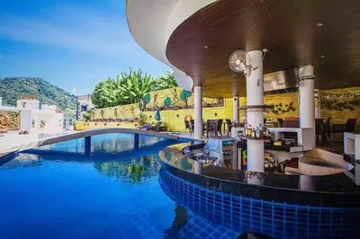 a swimming pool at a resort with blue water at Bay Shore Ocean View by Get A Rent Phuket in Patong Beach