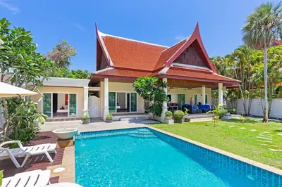 a villa with a swimming pool in front of a house at 3BR Villa Barnabé with Lush Garden in Rawai Beach