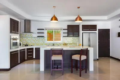 a kitchen with a large island with bar stools at 3BR Villa Barnabé with Lush Garden in Rawai Beach