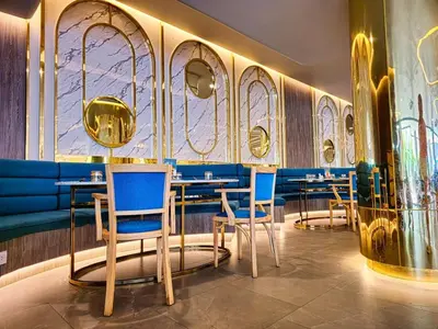 a restaurant with blue chairs and tables and a wall of windows at New Studio in 5 Hotel 500m to Rawai beach in Phuket Town