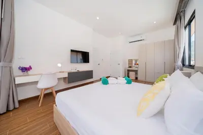 a white bedroom with a large bed and a tv at Goldena Twin Project - 3 Bedrooms Pool Villa in Kamala Beach