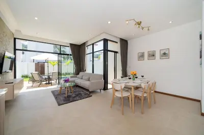 a living room with a table and a couch at Goldena Twin Project - 3 Bedrooms Pool Villa in Kamala Beach