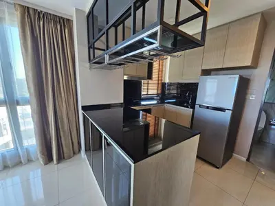 a kitchen with a black counter top and a refrigerator at 2-Bedrooms Seaview Suite in Surin Beach in Surin Beach