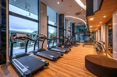 a row of treadmills in a gym with windows at 2-Bedrooms Seaview Suite in Surin Beach in Surin Beach