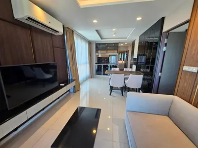 a living room with a television and a couch and a table at 2-Bedrooms Seaview Suite in Surin Beach in Surin Beach