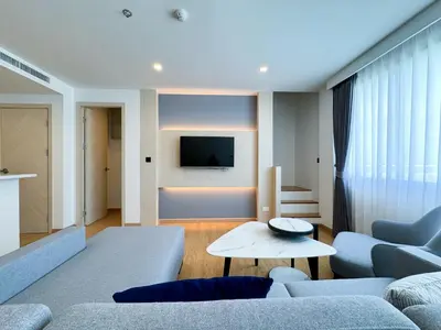 a living room with a couch and a tv at Duplex Cala 1BR FamilyPoolsGym Shuttle in Rawai Beach