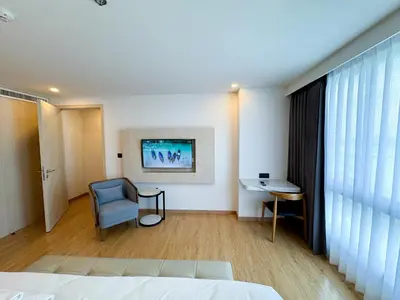 a bedroom with a bed and a chair and a desk at Duplex Cala 1BR FamilyPoolsGym Shuttle in Rawai Beach