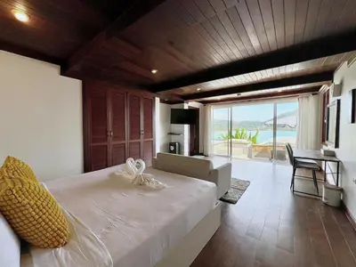 a bedroom with a bed with a view of the ocean at Jaokhun Bayview Kamala, Phuket in Kamala Beach