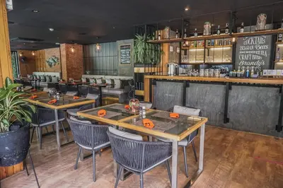 a restaurant with tables and chairs and a bar at Diamond Resort in Bang Tao Beach