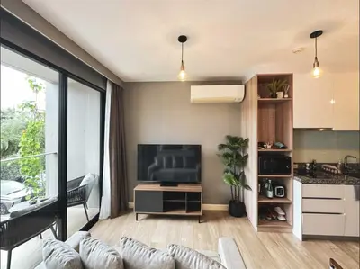 a living room with a couch and a tv and a kitchen at Diamond Resort in Bang Tao Beach