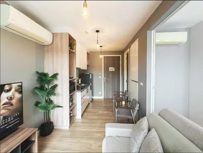 a living room with a couch and a kitchen at Diamond Resort in Bang Tao Beach