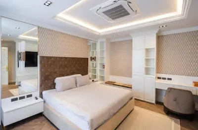 a bedroom with a large bed and a desk at Gold Chariot in Laguna Phuket