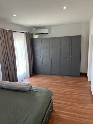a bedroom with a bed and a wooden floor at Villa PalmSprings in Ban Phak Chit