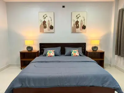 a bedroom with a blue bed with two lamps at The Nice Garden Home in Kata Beach